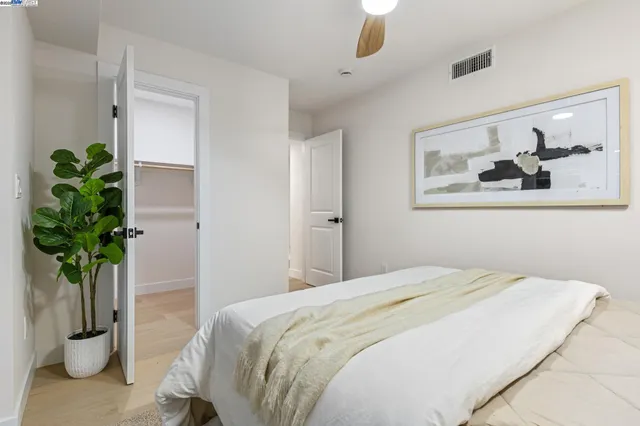 a spacious bedroom with a bed and a potted plant