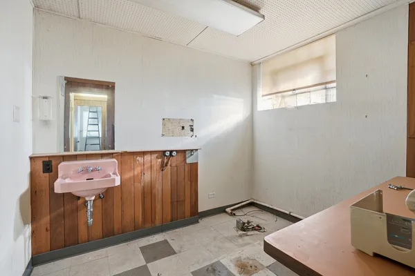 a kitchen with a sink a stove and a wooden floor