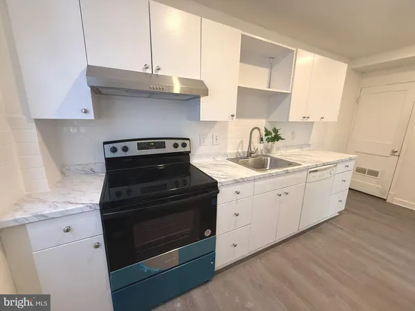 a kitchen with granite countertop white cabinets and black appliances