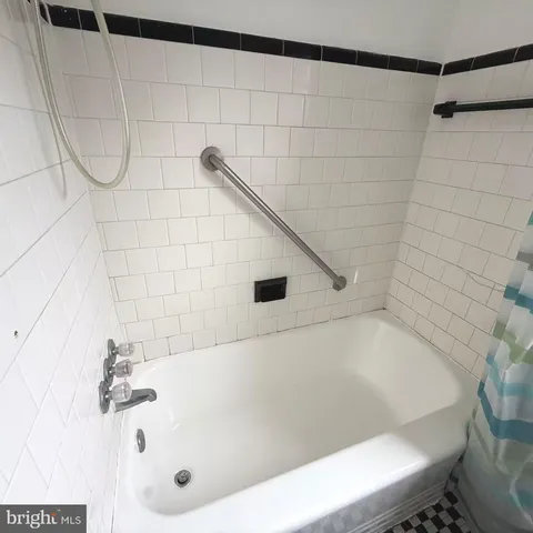 a bathroom with a white bath tub and a shower