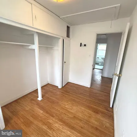 an empty room with wooden floor and window