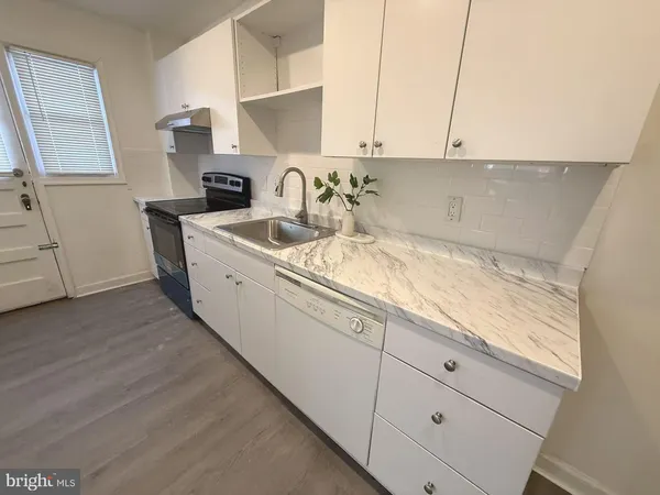 a kitchen with appliances a sink and cabinets