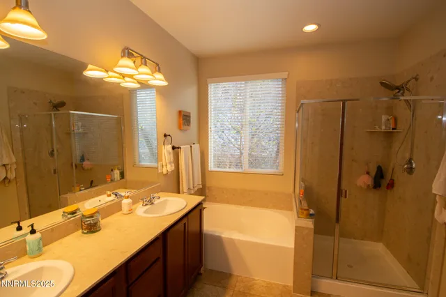 a bathroom with a tub shower sink and mirror