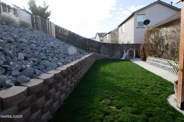 a view of a backyard with wooden fence