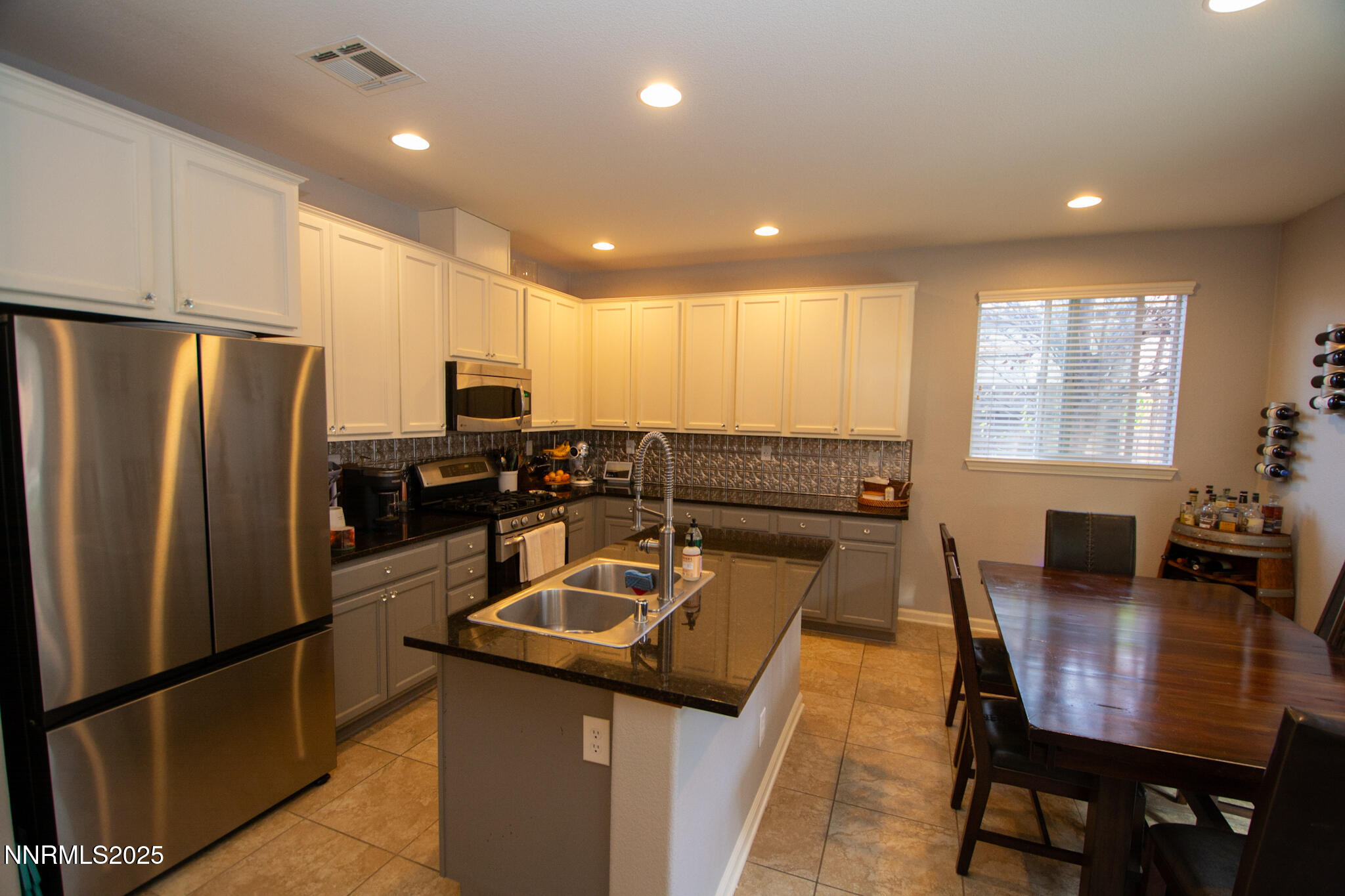 1056 Crown View Drive Reno, NV 89523 - Photo 6 of 27 a kitchen with stainless steel appliances granite countertop a refrigerator a stove a dining table and chairs