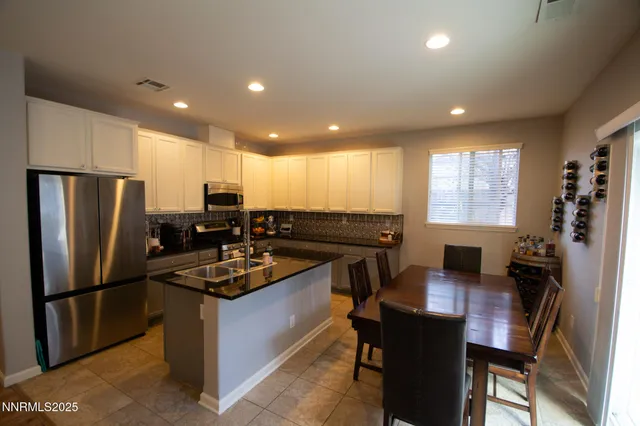 a kitchen with kitchen island a counter top space cabinets stainless steel appliances and a window