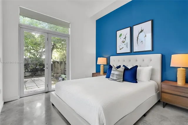 a large bed sitting in a bedroom next to a window