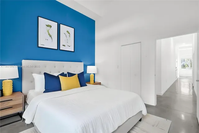 a bedroom with a bed and painting on the wall