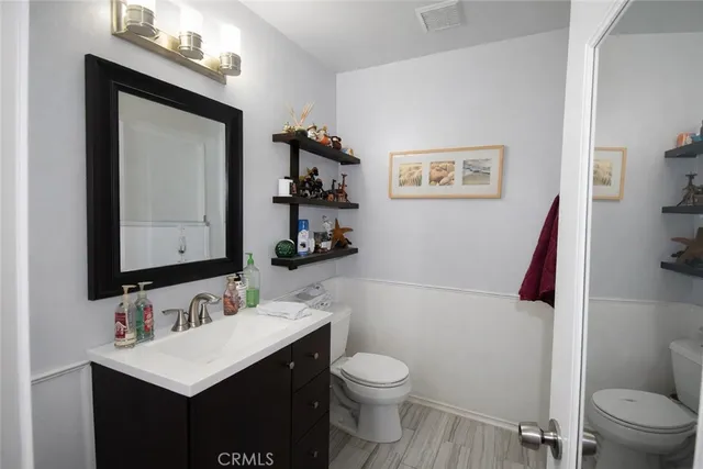 a bathroom with a sink vanity mirror and toilet