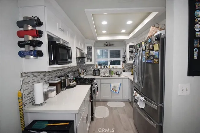 a kitchen with a sink stainless steel appliances and cabinets