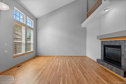a view of empty room with wooden floor and fireplace