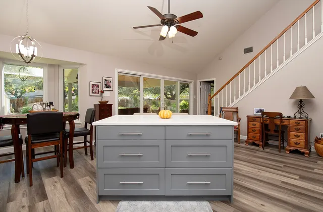 a kitchen with a table chairs and a ceiling fan