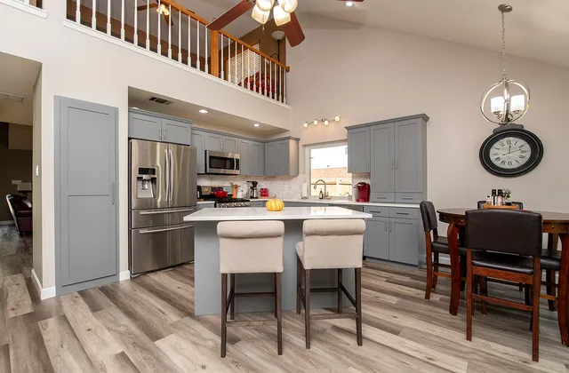 a living room with stainless steel appliances kitchen island granite countertop furniture a rug and a kitchen view