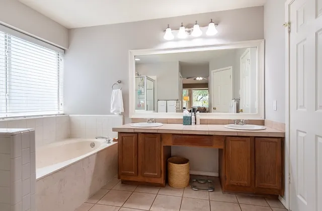 a bathroom with a tub sink and mirror