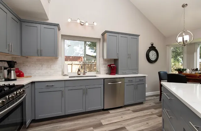 a kitchen with stainless steel appliances granite countertop a sink a stove and wooden floors
