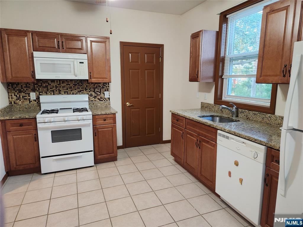 a kitchen with stainless steel appliances granite countertop a stove a sink and a granite counter tops