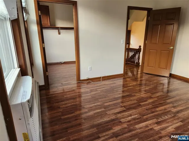 an empty room with wooden floor and entrance