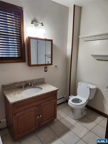 a bathroom with a granite countertop toilet sink and mirror