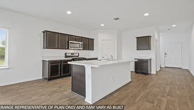 a kitchen with sink cabinets and stainless steel appliances