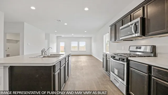 a kitchen with stainless steel appliances granite countertop a sink stove and microwave