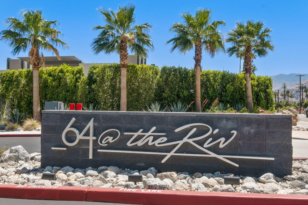 211 The River Palm Springs, CA 92262 - Photo 21 of 21 a street sign with a flower garden
