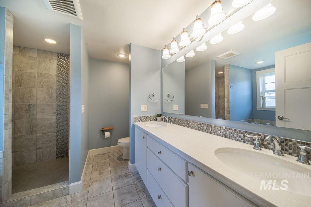 19809 Tammany Creek Road Lewiston, ID 83501 - Photo 18 of 50 Bathroom with walk in shower, tasteful backsplash, and light tile patterned flooring