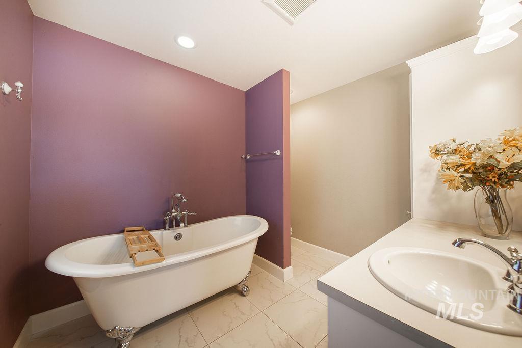 19809 Tammany Creek Road Lewiston, ID 83501 - Photo 32 of 50 Bathroom with a freestanding bath, light marble finish floors, vanity, and recessed lighting