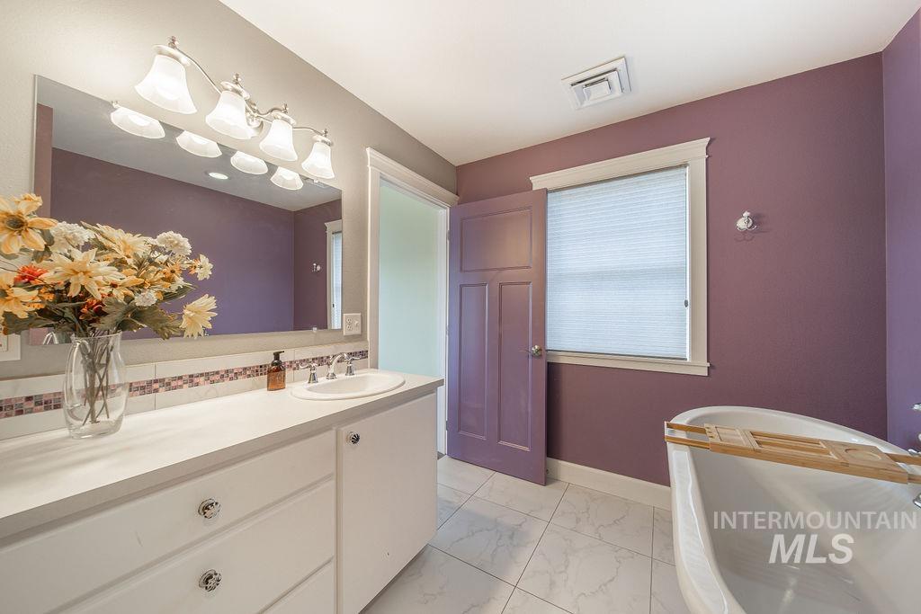 19809 Tammany Creek Road Lewiston, ID 83501 - Photo 33 of 50 Bathroom featuring a freestanding tub, light marble finish floors, and vanity