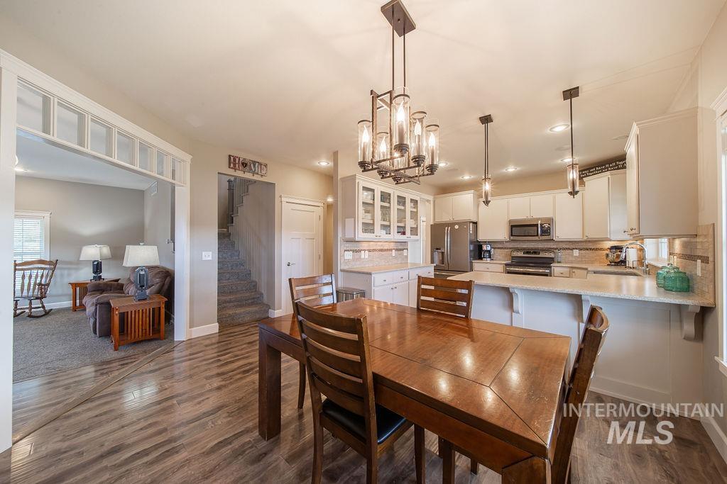 19809 Tammany Creek Road Lewiston, ID 83501 - Photo 9 of 50 Dining space with dark wood-style floors, a chandelier, stairway, and recessed lighting