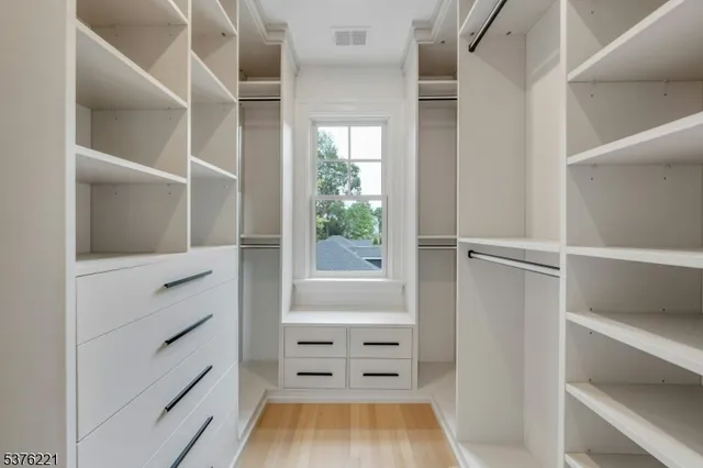 a bathroom with a granite countertop double vanity sink a mirror and a bathtub