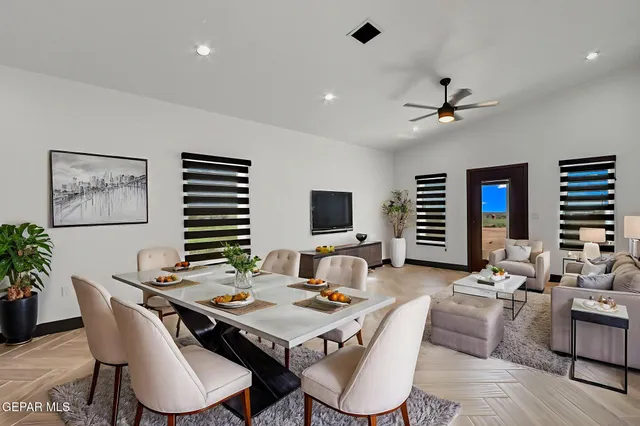 a living room with furniture a flat screen tv and a table