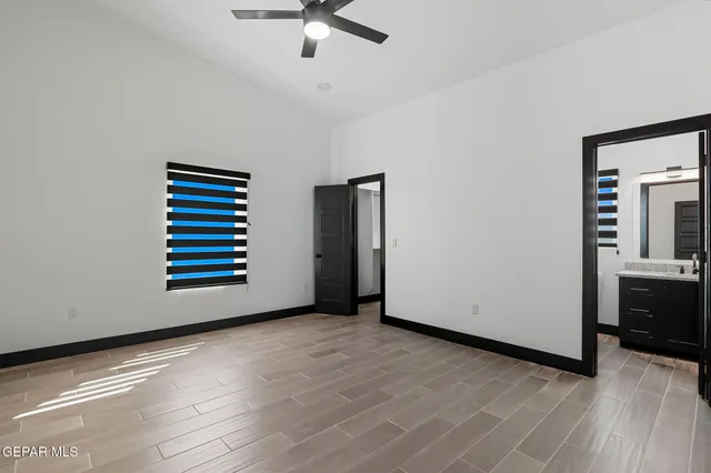 a view of an empty room with a kitchen and a window