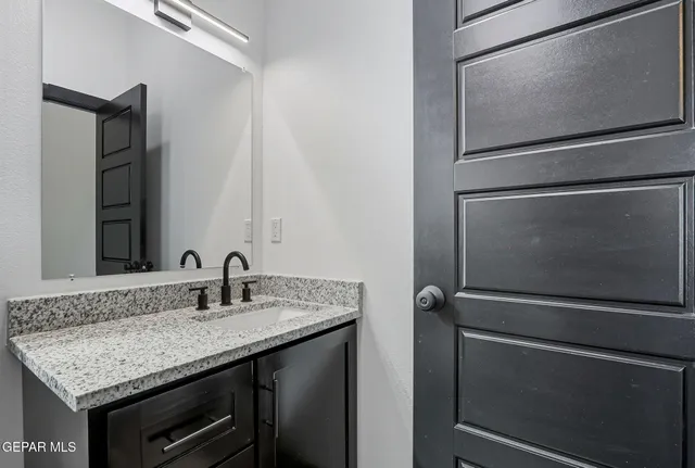 a bathroom with a granite countertop sink and a mirror
