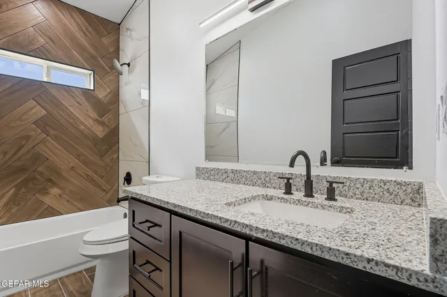 a bathroom with a granite countertop sink and a mirror