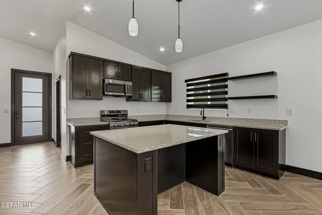 a kitchen with a center island appliances and cabinets