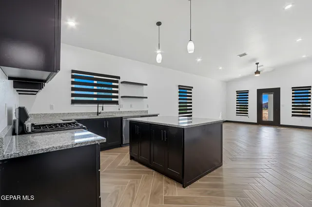 a kitchen with stainless steel appliances granite countertop a stove a sink and a refrigerator