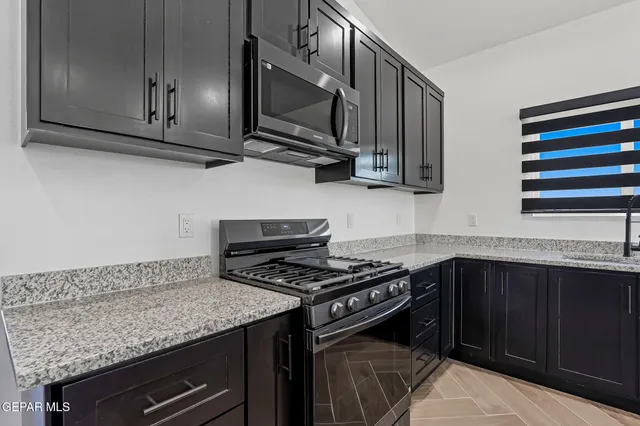 a kitchen with stainless steel appliances granite countertop a stove and a microwave