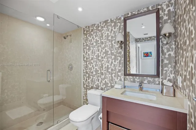 a bathroom with a granite countertop sink toilet a mirror and shower