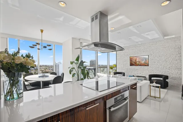 a kitchen with stainless steel appliances a sink a counter space and a view of living room