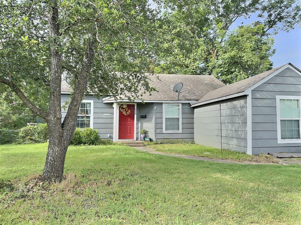 a front view of a house with a yard and trees