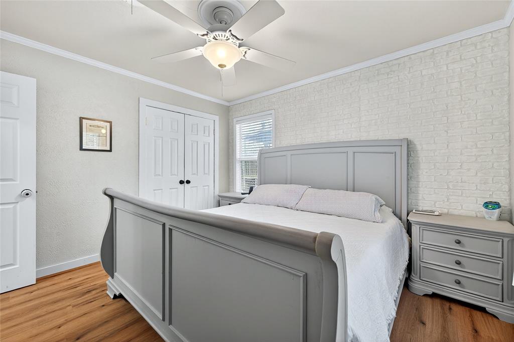 1115 Oak Ridge Drive Denison, TX 75020 - Photo 20 of 32 a bedroom with a bed and a chandelier