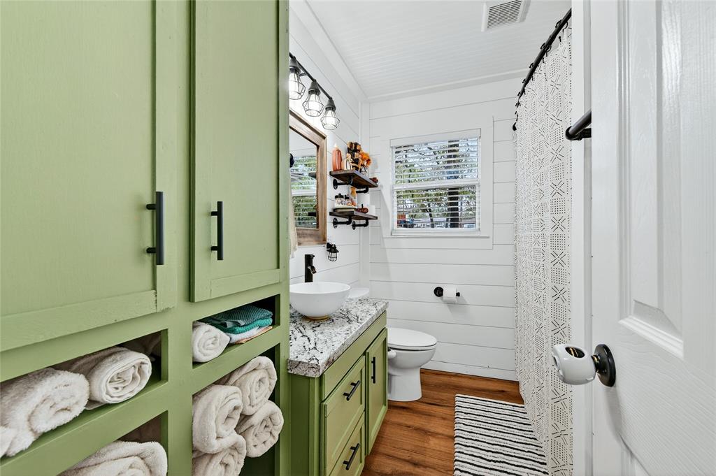 1115 Oak Ridge Drive Denison, TX 75020 - Photo 22 of 32 a bathroom with a sink a toilet and shower