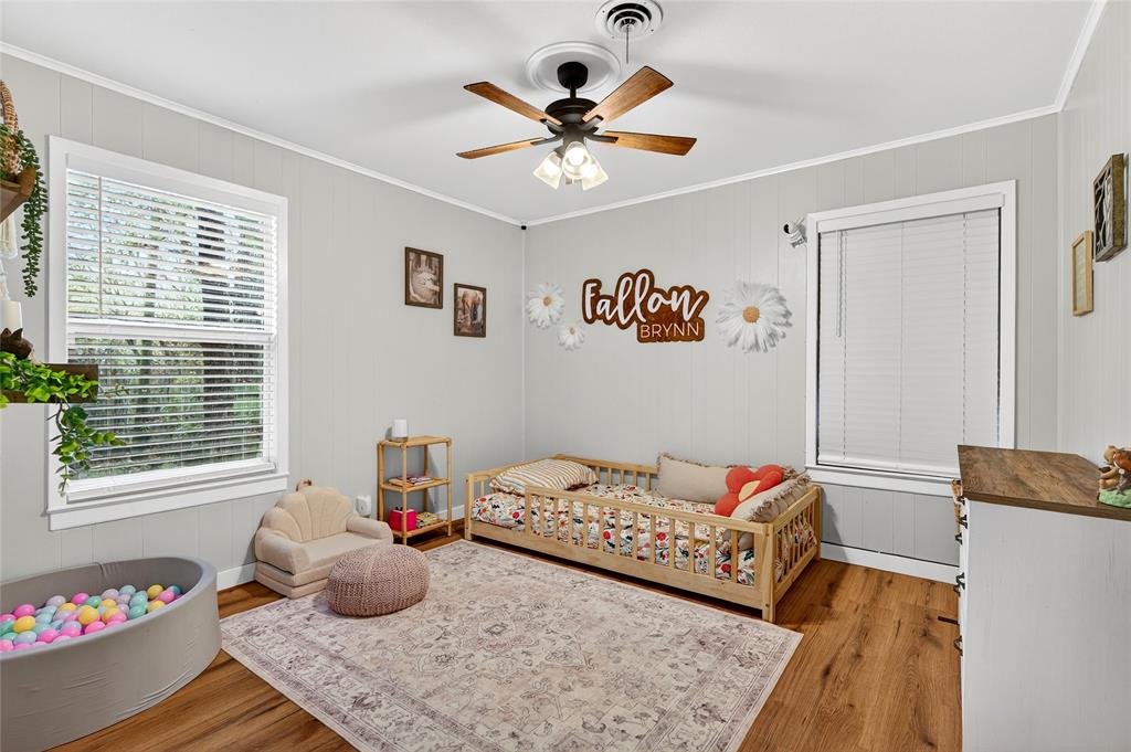 1115 Oak Ridge Drive Denison, TX 75020 - Photo 24 of 32 a bedroom with a bed and a chandelier