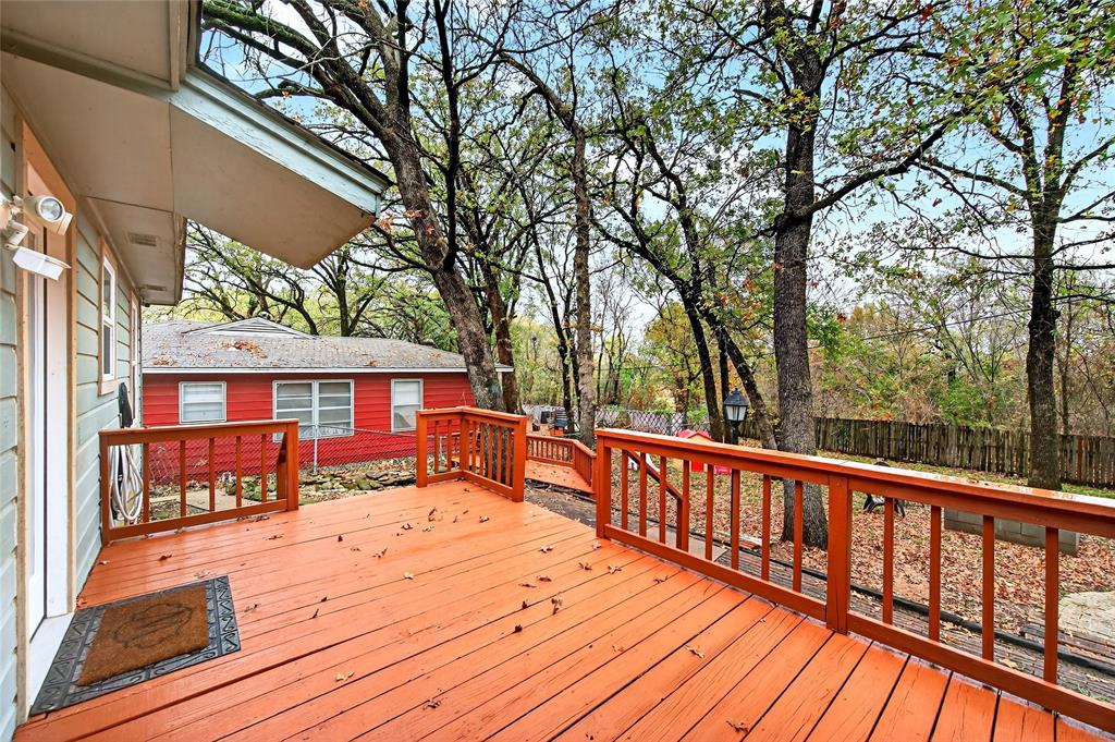 1115 Oak Ridge Drive Denison, TX 75020 - Photo 26 of 32 a view of a roof deck with wooden fence and large trees