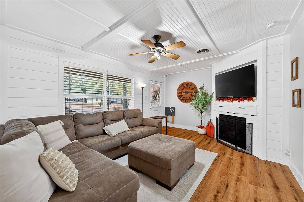 1115 Oak Ridge Drive Denison, TX 75020 - Photo 6 of 32 a living room with furniture a flat screen tv and a fireplace