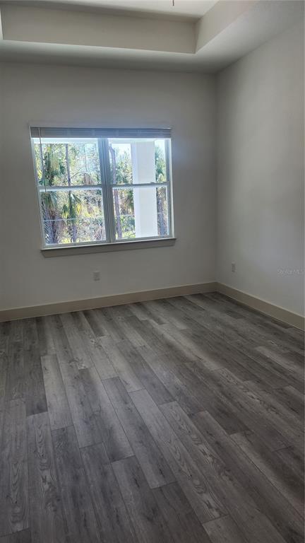 23469 Roscoe Avenue Punta Gorda, FL 33980 - Photo 13 of 26 an empty room with wooden floor and windows