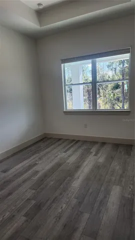 a view of a room that has wooden floor and large window
