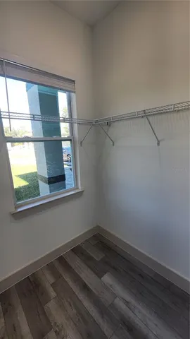 a view of a room that has a window and wooden floor