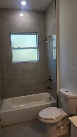 a white toilet sitting next to a bath tub