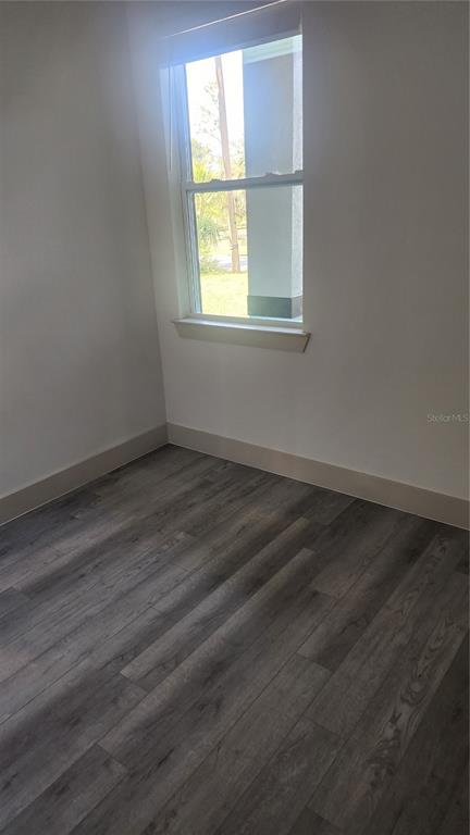 23469 Roscoe Avenue Punta Gorda, FL 33980 - Photo 22 of 26 an empty room with wooden floor and windows